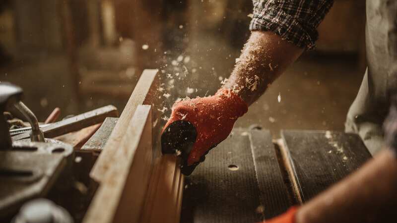 Carpenter works with manual and electric equipment