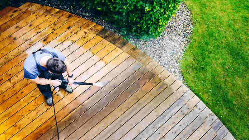 high water pressure cleaner on wooden terrace surface