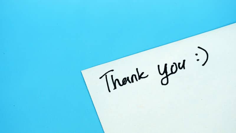 Handwritten words of thank you on a light blue background